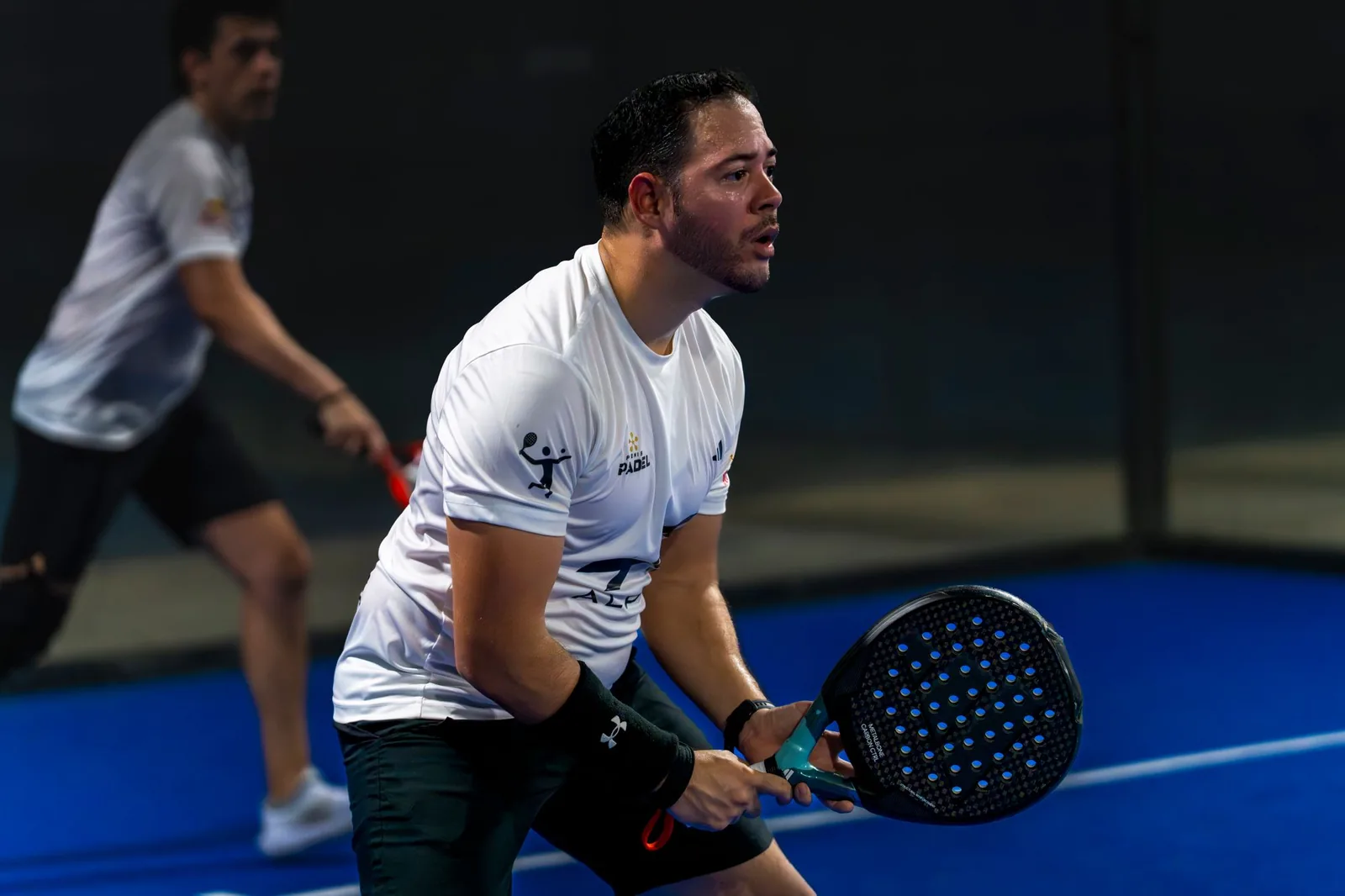 A padel player waiting at the net